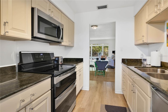 700 Melrose Ave Unit L-23, Winter Park, FL 32789 - kitchen with dark stone countertops, visible vents, a sink, light wood finished floors, and stainless steel appliances