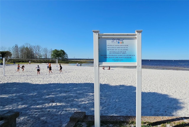 view of property's community with volleyball court, a beach view, and a water view