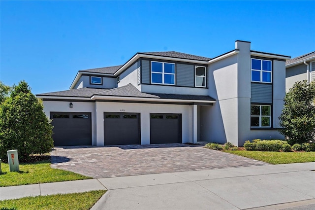 16975 Wingspread Loop, Winter Garden, FL 34787 - view of front of property with stucco siding, decorative driveway, a shingled roof, and a garage
