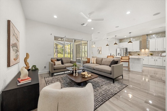 living room featuring recessed lighting, a ceiling fan, and baseboards