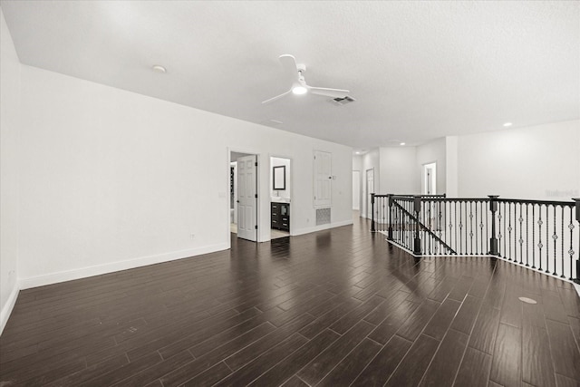 empty room with wood finished floors, baseboards, visible vents, ceiling fan, and a textured ceiling