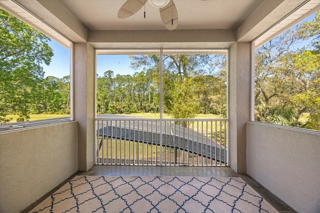 unfurnished sunroom with a ceiling fan