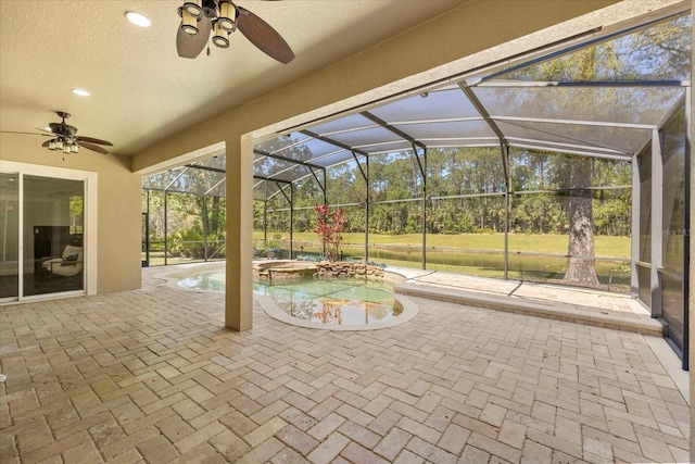 view of patio with a lanai, a pool with connected hot tub, and ceiling fan