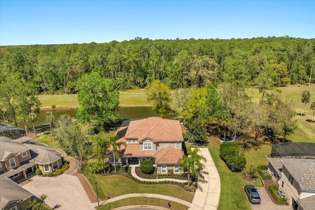 drone / aerial view with a forest view and a water view