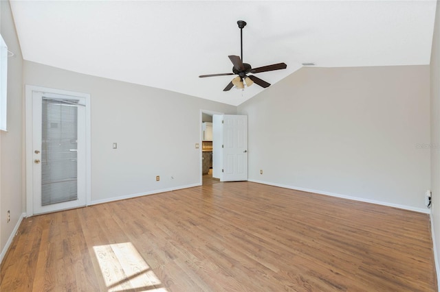 empty room featuring baseboards, light wood finished floors, ceiling fan, and vaulted ceiling