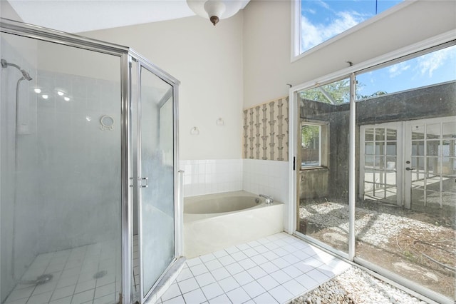 bathroom with french doors, a bath, tile patterned floors, and a shower stall