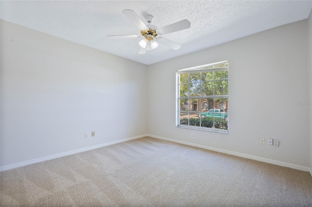 empty room featuring carpet flooring, a textured ceiling, and baseboards