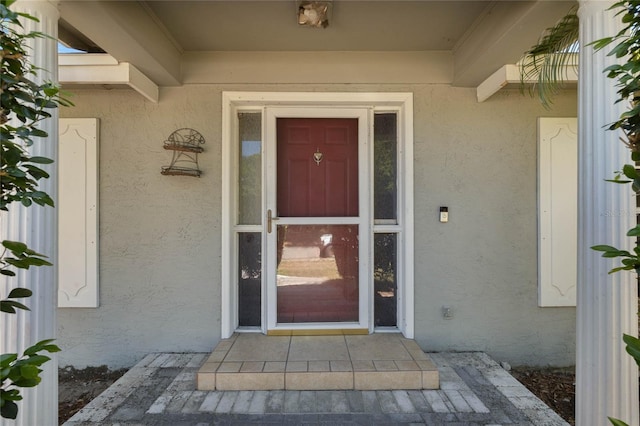 doorway to property featuring stucco siding