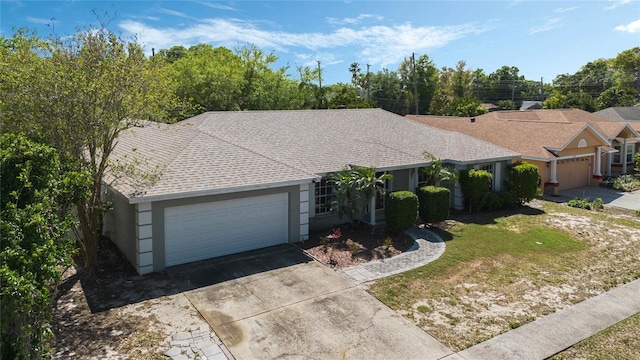 ranch-style home featuring driveway, a garage, a front lawn, a shingled roof, and stucco siding
