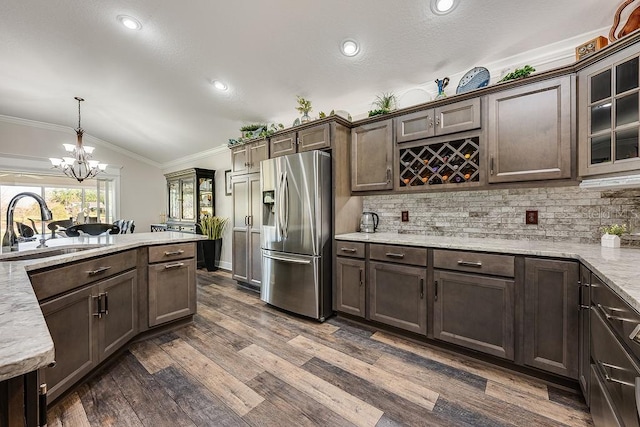 5729 Hickey Way, The Villages, FL 32163 - kitchen with a notable chandelier, crown molding, a sink, lofted ceiling, and stainless steel refrigerator with ice dispenser