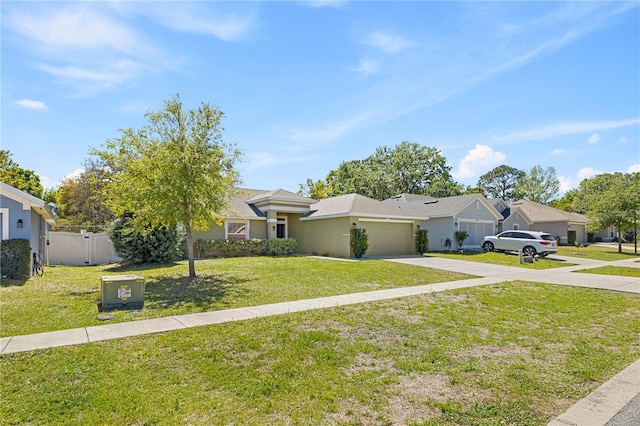 ranch-style home with fence, an attached garage, concrete driveway, a front lawn, and a residential view