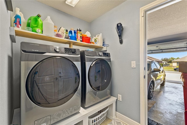 washroom featuring a textured ceiling, laundry area, baseboards, washer and dryer, and a textured wall