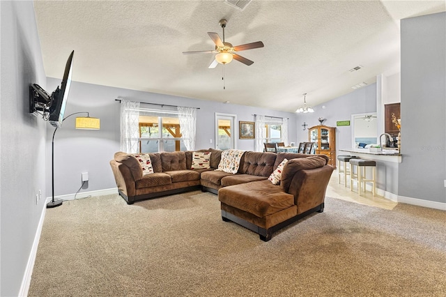 living area featuring vaulted ceiling, light carpet, a textured ceiling, baseboards, and ceiling fan with notable chandelier