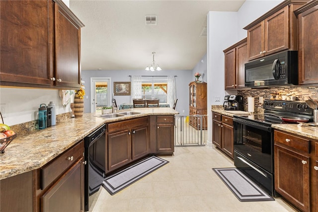 kitchen with a sink, a peninsula, visible vents, black appliances, and an inviting chandelier