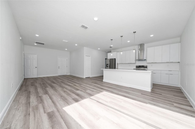 16407 SW 21st Terrace Rd, Ocala, FL 34473 - kitchen featuring wall chimney exhaust hood, appliances with stainless steel finishes, visible vents, white cabinets, and light wood-style floors