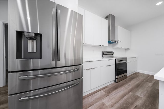 16407 SW 21st Terrace Rd, Ocala, FL 34473 - kitchen with light countertops, wall chimney exhaust hood, wood finished floors, stainless steel appliances, and white cabinets