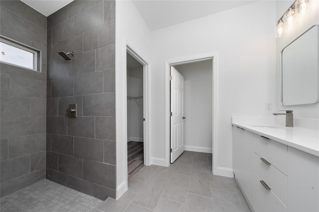 16407 SW 21st Terrace Rd, Ocala, FL 34473 - bathroom with baseboards, vanity, tiled shower, a spacious closet, and tile patterned flooring