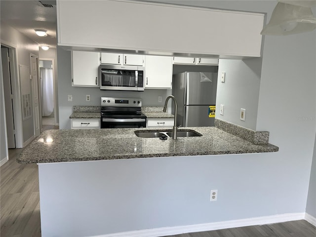 2020 Royal Bay Blvd Unit 92, Kissimmee, FL 34746 - kitchen featuring appliances with stainless steel finishes, a sink, light wood finished floors, and white cabinets