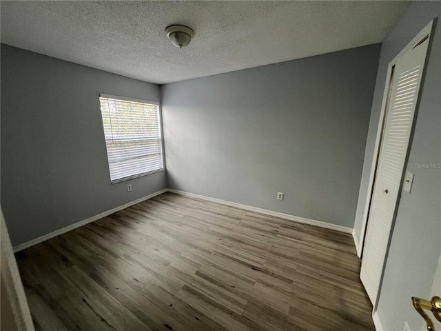 2020 Royal Bay Blvd Unit 92, Kissimmee, FL 34746 - unfurnished bedroom with wood finished floors, baseboards, a closet, and a textured ceiling