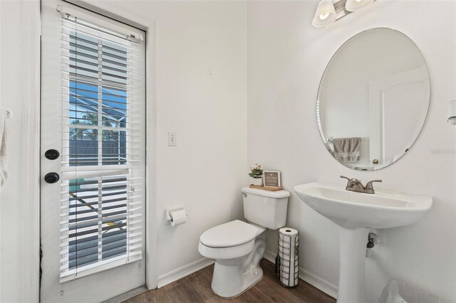 bathroom featuring toilet, baseboards, and wood finished floors