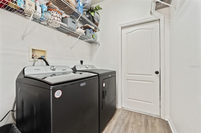 laundry room with washer and dryer, light wood-type flooring, laundry area, and baseboards