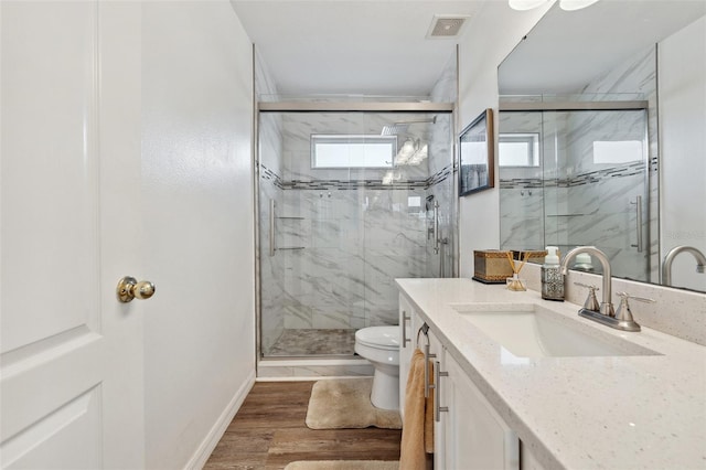 full bath featuring toilet, vanity, visible vents, and a marble finish shower