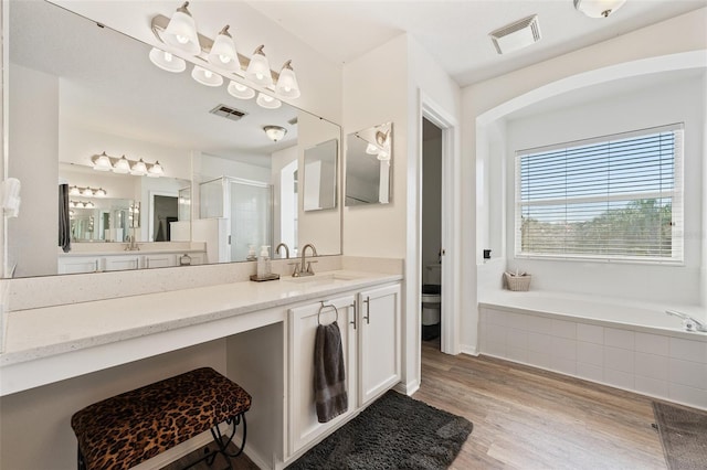 full bathroom featuring a shower stall, visible vents, a garden tub, and wood finished floors