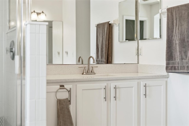 full bath featuring tiled shower and vanity