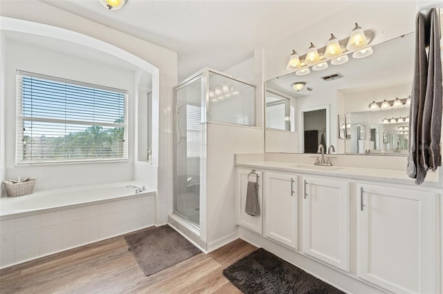 full bath with a garden tub, a stall shower, wood finished floors, and vanity