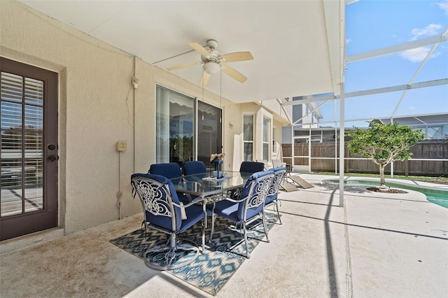 view of patio with ceiling fan, fence, a fenced in pool, and glass enclosure