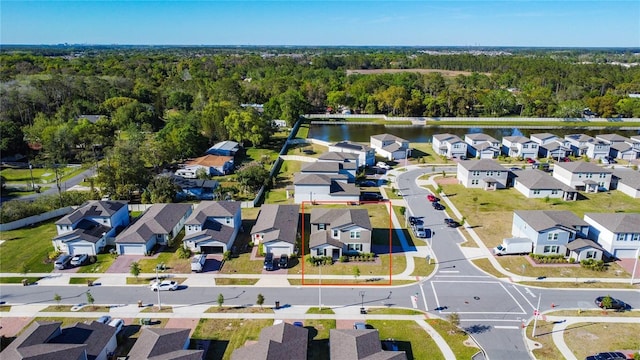 birds eye view of property featuring a residential view, a wooded view, and a water view