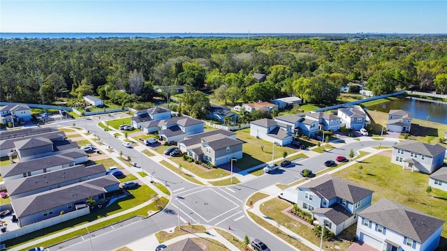 birds eye view of property featuring a residential view, a wooded view, and a water view