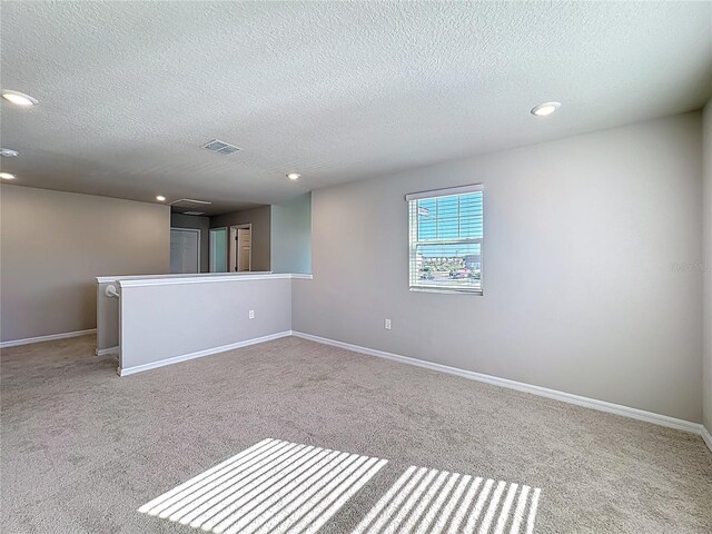 empty room with recessed lighting, visible vents, and baseboards