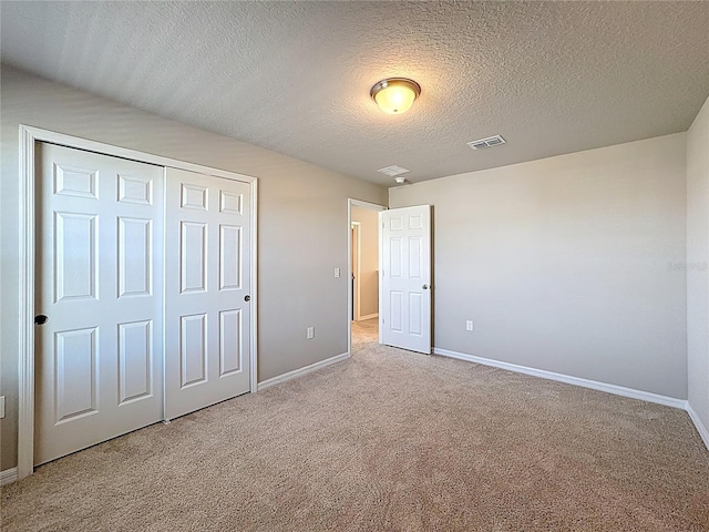 unfurnished bedroom with carpet flooring, baseboards, visible vents, and a closet