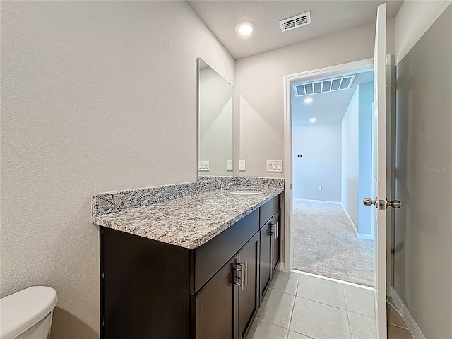 bathroom featuring vanity, tile patterned floors, toilet, and visible vents