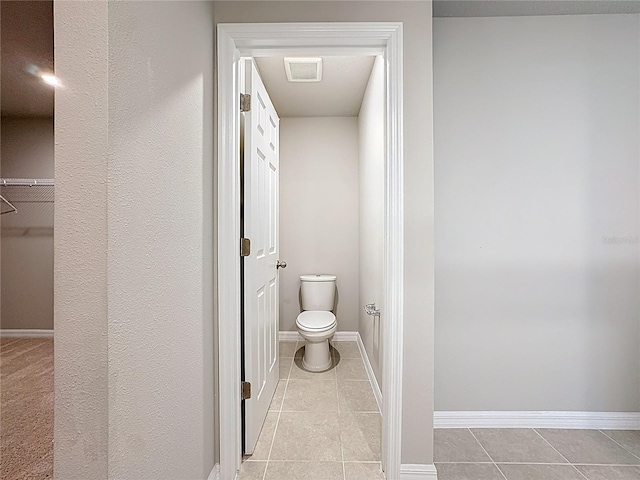 bathroom with tile patterned flooring, toilet, visible vents, and baseboards