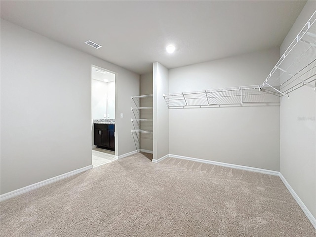 spacious closet featuring visible vents and light carpet