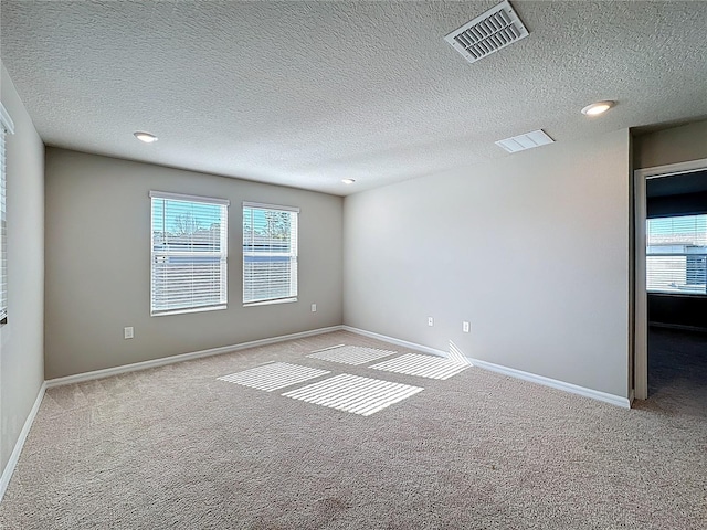 empty room with carpet flooring, baseboards, and visible vents