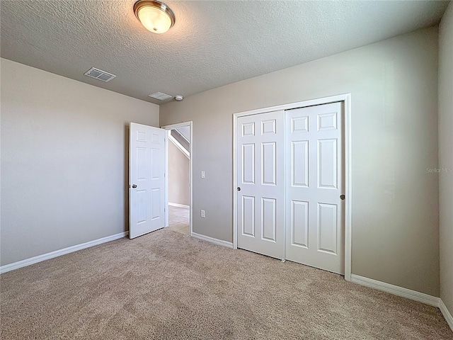 unfurnished bedroom featuring light carpet, visible vents, baseboards, and a closet