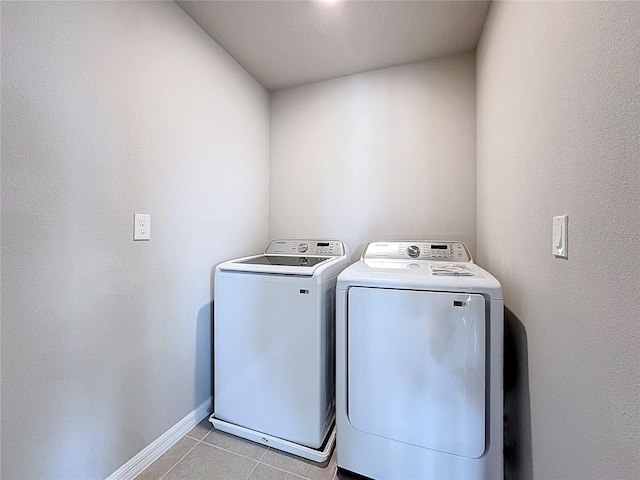washroom with washer and dryer, laundry area, baseboards, and tile patterned flooring