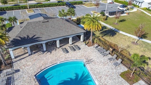 community pool with a patio area and fence