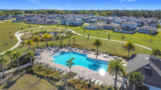 community pool featuring a residential view, a patio, and fence