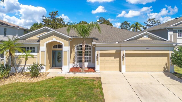 view of front of home with stucco siding, a garage, concrete driveway, and a shingled roof