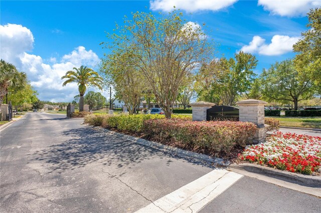 view of road featuring a gate, curbs, and a gated entry
