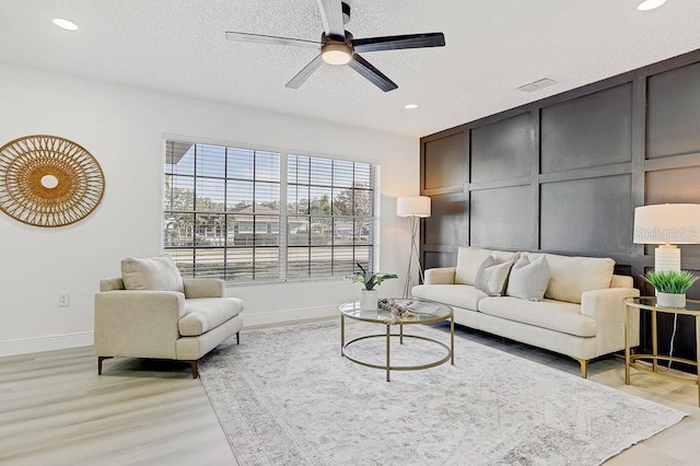 4907 21st Ave W, Bradenton, FL 34209 - living area with visible vents, baseboards, ceiling fan, light wood-style flooring, and a textured ceiling