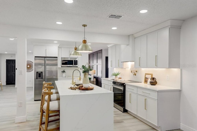 4907 21st Ave W, Bradenton, FL 34209 - kitchen with stainless steel appliances, visible vents, light countertops, and white cabinetry