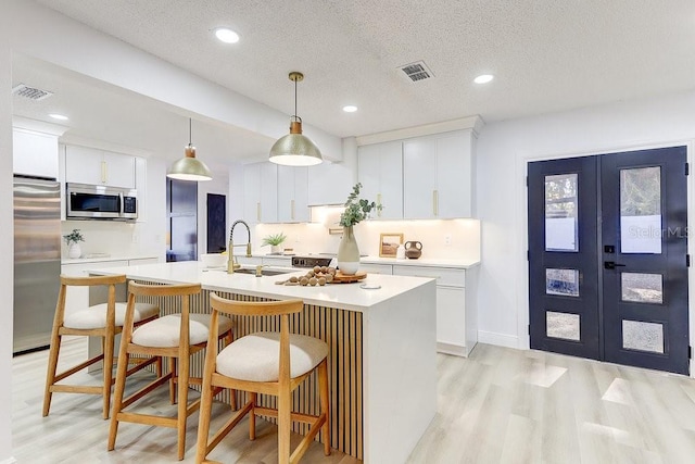 4907 21st Ave W, Bradenton, FL 34209 - kitchen with visible vents, light countertops, french doors, stainless steel appliances, and a sink