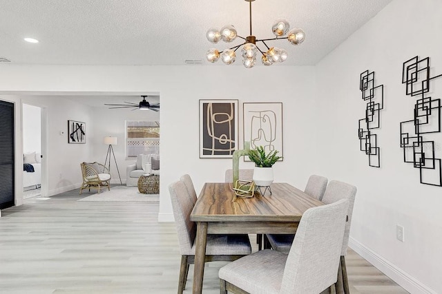 4907 21st Ave W, Bradenton, FL 34209 - dining space featuring baseboards, recessed lighting, light wood-style floors, a textured ceiling, and ceiling fan with notable chandelier