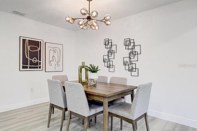 4907 21st Ave W, Bradenton, FL 34209 - dining area with baseboards, visible vents, a textured ceiling, light wood-type flooring, and a chandelier