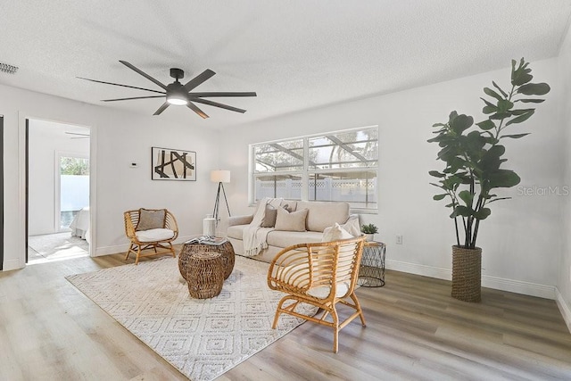 4907 21st Ave W, Bradenton, FL 34209 - living room with visible vents, baseboards, wood finished floors, a textured ceiling, and a ceiling fan